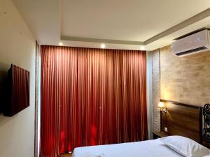 a bedroom with a red curtain and a bed at Hotel Nalba Jupiter in Jupiter