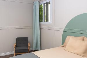 a bedroom with a chair and a bed and a window at Hotel Otoya 1907 Downtown in San José