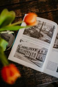 ein offenes Buch auf einem Holztisch mit einer Blume in der Unterkunft Hotel Renesse in Renesse