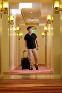 Een man in een hal met een koffer. bij ROYAL J HOTEL in Cebu City