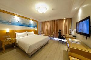 a hotel room with a bed and a flat screen tv at ROYAL J HOTEL in Cebu City