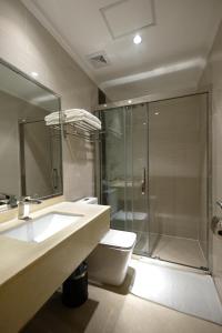 een badkamer met een douche, een toilet en een wastafel bij ROYAL J HOTEL in Cebu City