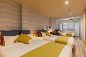 a hotel room with two beds with yellow and white at Southerlies Condominium Onna in Onna