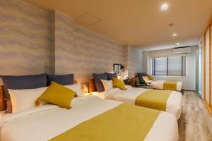 a hotel room with two beds with yellow and white at Southerlies Condominium Onna in Onna