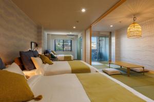 a hotel room with two beds and a table at Southerlies Condominium Onna in Onna