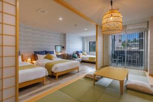 a hotel room with two beds and a balcony at Southerlies Condominium Onna in Onna