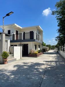 a large white house with a driveway at Melinda’s Private Resort in Tarlac