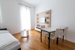 1 dormitorio con mesa de comedor y sillas en sHome Hotel Graz - Self-Check-in & free parking, en Graz