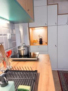 a kitchen with white cabinets and a pot on a stove at Art & Design Studios in Budapest +76 photos