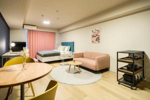 um quarto com uma cama, um sofá e uma mesa em Section L Residence Ginza em Tóquio