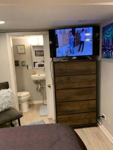 um quarto com uma televisão em cima de uma cómoda em 15 min Ohare/Rivers Casino/Downtown & Parking1 em Chicago