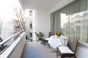 a balcony with a table and chairs and a window at im 2ten Business Apartments in Vienna