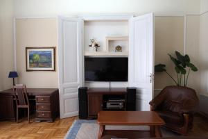 - un salon avec une télévision, une chaise et une table dans l'établissement GoldStar Osijek, à Osijek