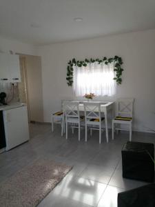 una sala da pranzo bianca con tavolo e sedie bianchi di Horvath apartman a Keszthely