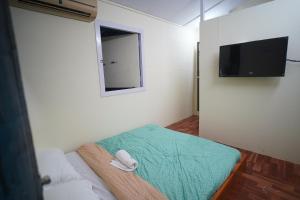 a small room with a bed and a television at Maati Nature Resort in Kankauli