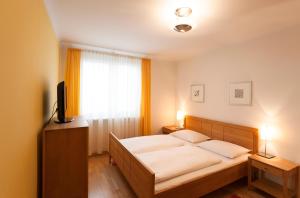 a bedroom with a bed and a television and a window at im 2ten Business Apartments in Vienna