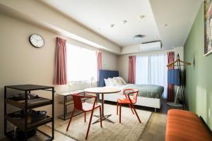 a bedroom with a bed and a table and chairs at Section L Residence Ginza in Tokyo