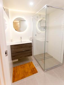 a bathroom with a glass shower and a sink at Coolum Sands Beachside Apartment in Coolum Beach