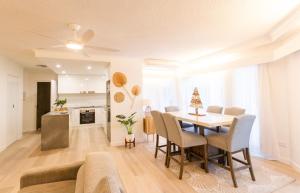 a living room with a dining room table and a couch at Coolum Sands Beachside Apartment in Coolum Beach