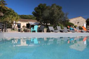 a swimming pool with chairs and a group of people at Villa del Ré 6 in La Flotte