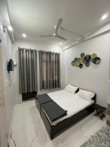 a bedroom with a bed and a ceiling fan at OLT HOSTEL in Rishīkesh