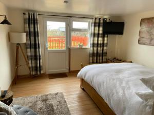 um quarto com uma cama e uma porta de vidro deslizante em Little Buttercup Cottage em Brackley