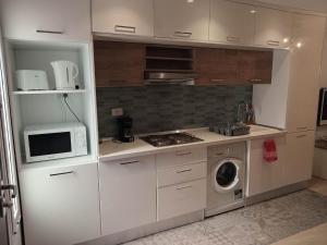 a kitchen with a microwave and a washing machine at Marsa BiBi in Tunis +1 photo