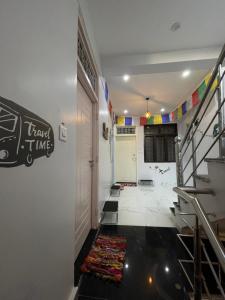 einen Flur mit einer Treppe und einer weißen Tür mit einem Schild drauf in der Unterkunft OLT HOSTEL in Rishikesh