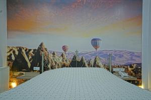 ウチヒサールにあるCappadocia Symbol Hotelの熱気球の絵付きのベッドルーム