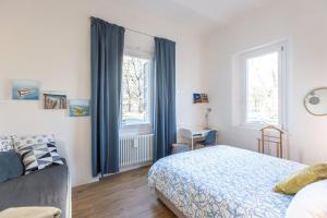 Schlafzimmer mit einem Bett und einem Fenster mit blauen Vorhängen in der Unterkunft CaseOspitali - Daimò, delizioso bilocale Fiera perfetto x5 in Bologna