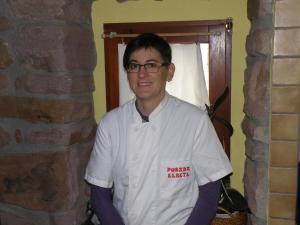 a man in a white shirt is standing in a room at Posada Elbete in Elbete