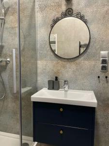 y baño con lavabo y espejo. en Lawendowy - Apartamenty Smart Projekt en Tarnów