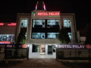 un palacio de hotel por la noche con sus luces encendidas en Hotel Palav Palace en Ahmedabad