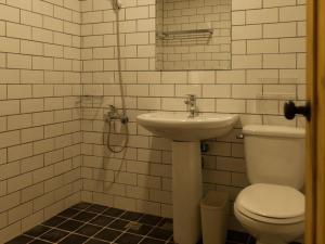 a white bathroom with a sink and a toilet at Mini Voyage Hostel in Hualien City