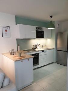 a kitchen with white cabinets and a counter top at Le Colisée du Plessis-parking gratuit in Le Plessis-Robinson