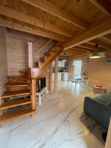 a living room with wooden ceilings and a staircase at Morski Zakątek in Rowy