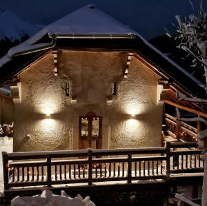 Couples Gem - Sensational views Nr Morzine في La Côte dʼArbroz: منزل به ثلج على السطح في الليل