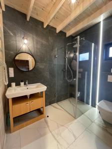 ein Bad mit einem Waschbecken und einer Dusche in der Unterkunft Morski Zakątek in Rowy