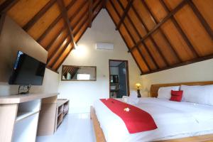een slaapkamer met een groot bed en een flatscreen-tv bij RedDoorz at Ocean 2 Gili Trawangan in Gili Trawangan