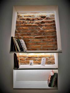 una libreria con libri di fronte a un muro di mattoni di Casa Belfiore Vicenza Martiri di Belfiore 23 a Vicenza