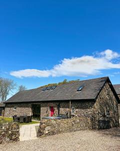 布什米爾斯的住宿－The Old Bushmills Barn，一座大型石头建筑,有黑色的屋顶