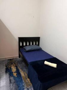 una camera da letto con un letto con un piumone blu e un cuscino di Totoi Melaka a Malacca 1 altra foto