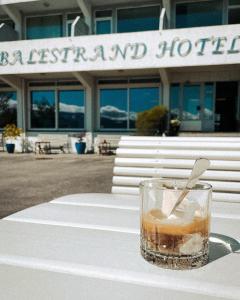 uma bebida sentada numa mesa em frente a um hotel em Balestrand Hotel em Balestrand