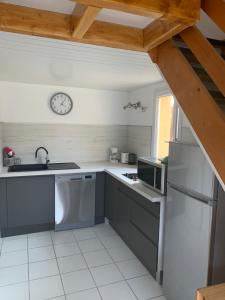 una cocina con fregadero y un reloj en la pared en Pavillons 7 et 56 Narbonne Plage, en Narbonne-Plage