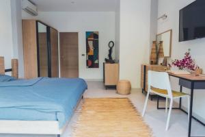 Un dormitorio con una cama, un escritorio y una mesa. en MAGNIFICENT SOUL VILLA, en Chaloklum