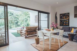 Una sala de estar con una mesa y sillas blancas. en MAGNIFICENT SOUL VILLA, en Chaloklum
