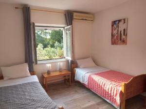 a bedroom with two beds and a window at Joleni Cottage in Keramies in Kefallonia