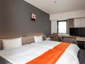 Säng eller sängar i ett rum på Niigata Daiichi Hotel