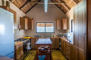 a kitchen with wooden cabinets and a table in it at Huntshoek Lodge in Grahamstown