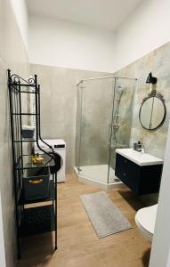 y baño con ducha y lavamanos. en Lawendowy - Apartamenty Smart Projekt en Tarnów